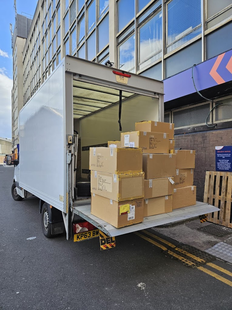 Merit Removals van loading packed boxes into a Luton van in Manchester